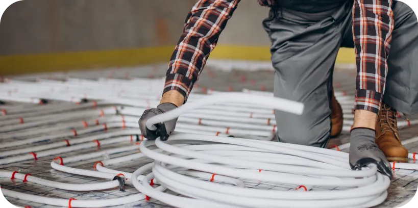 Pracownik firmy Sandersystem przygotowuje się do montażu ogrzewania podłogowego