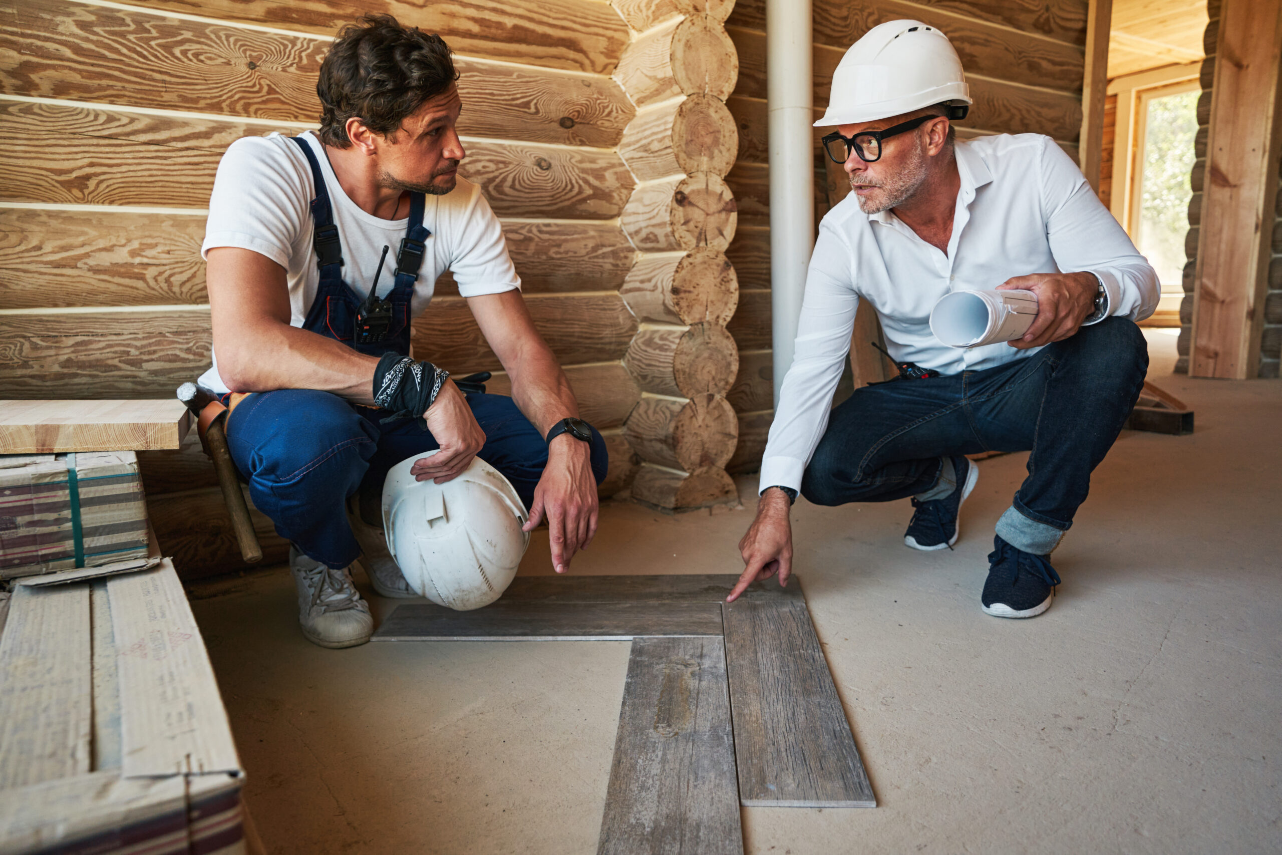 Construction engineer telling builder how to lay parquetry